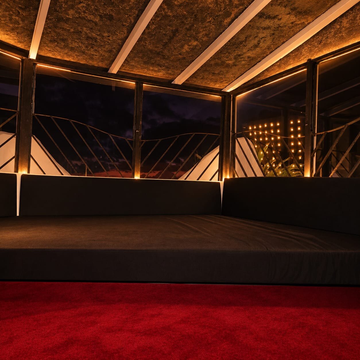 Large bed with red carpet and warm lights