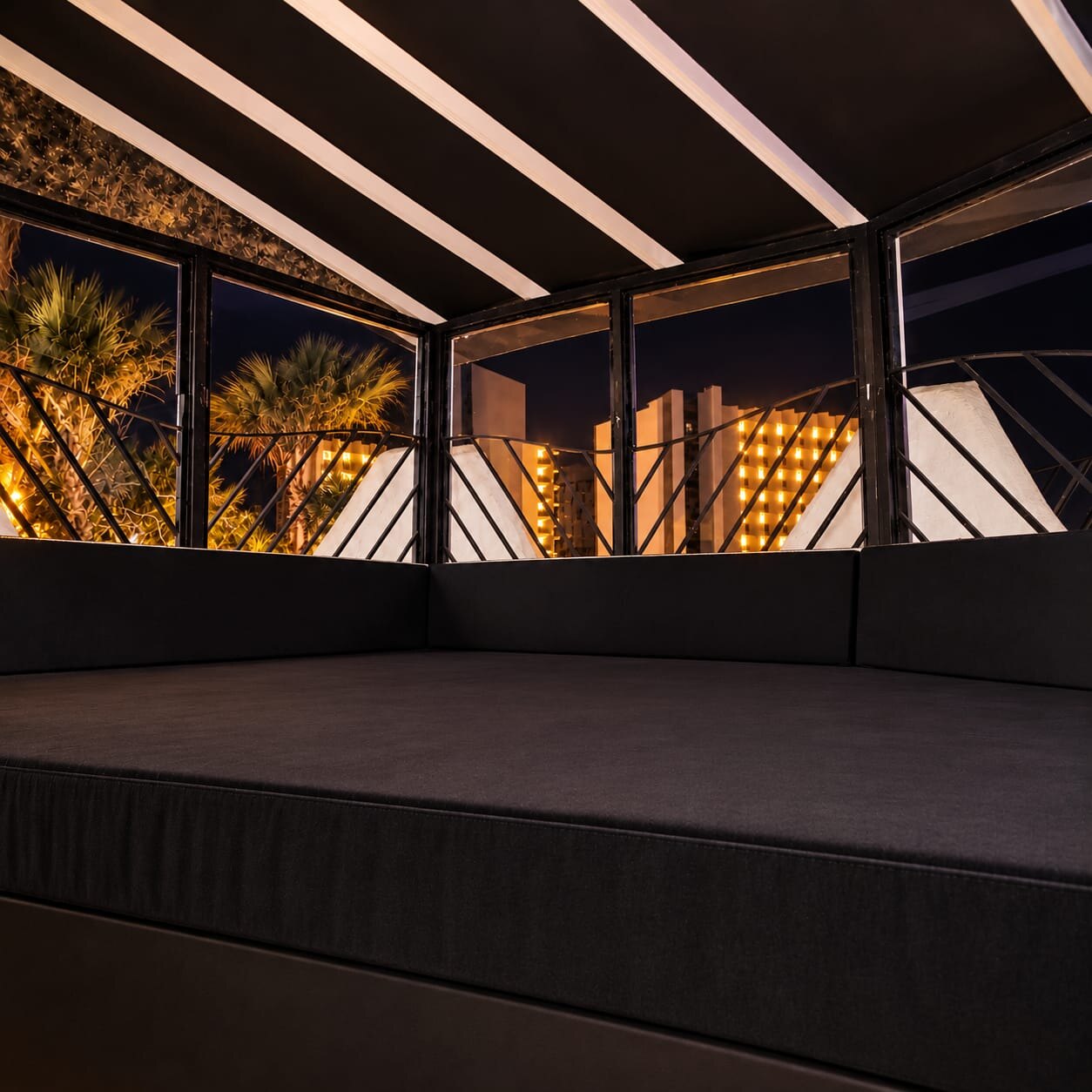 Lounge bed with palm trees and city lights