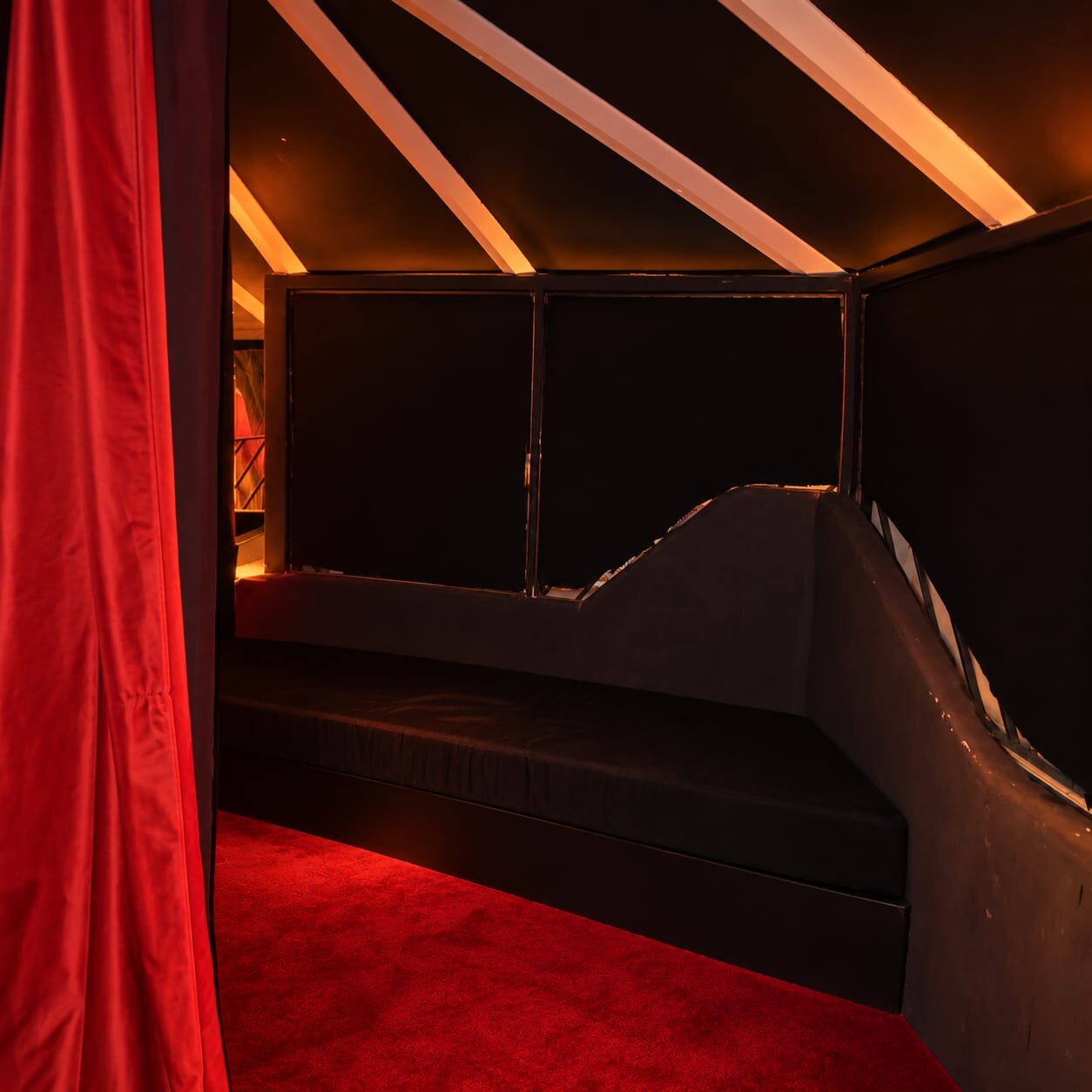 Private corner behind a red velvet curtain